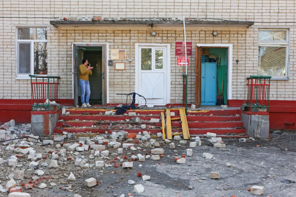 Женщина стоит у входа в здание детского сада, пострадавшее от обстрела в Белгороде, 20 марта 2024 года.