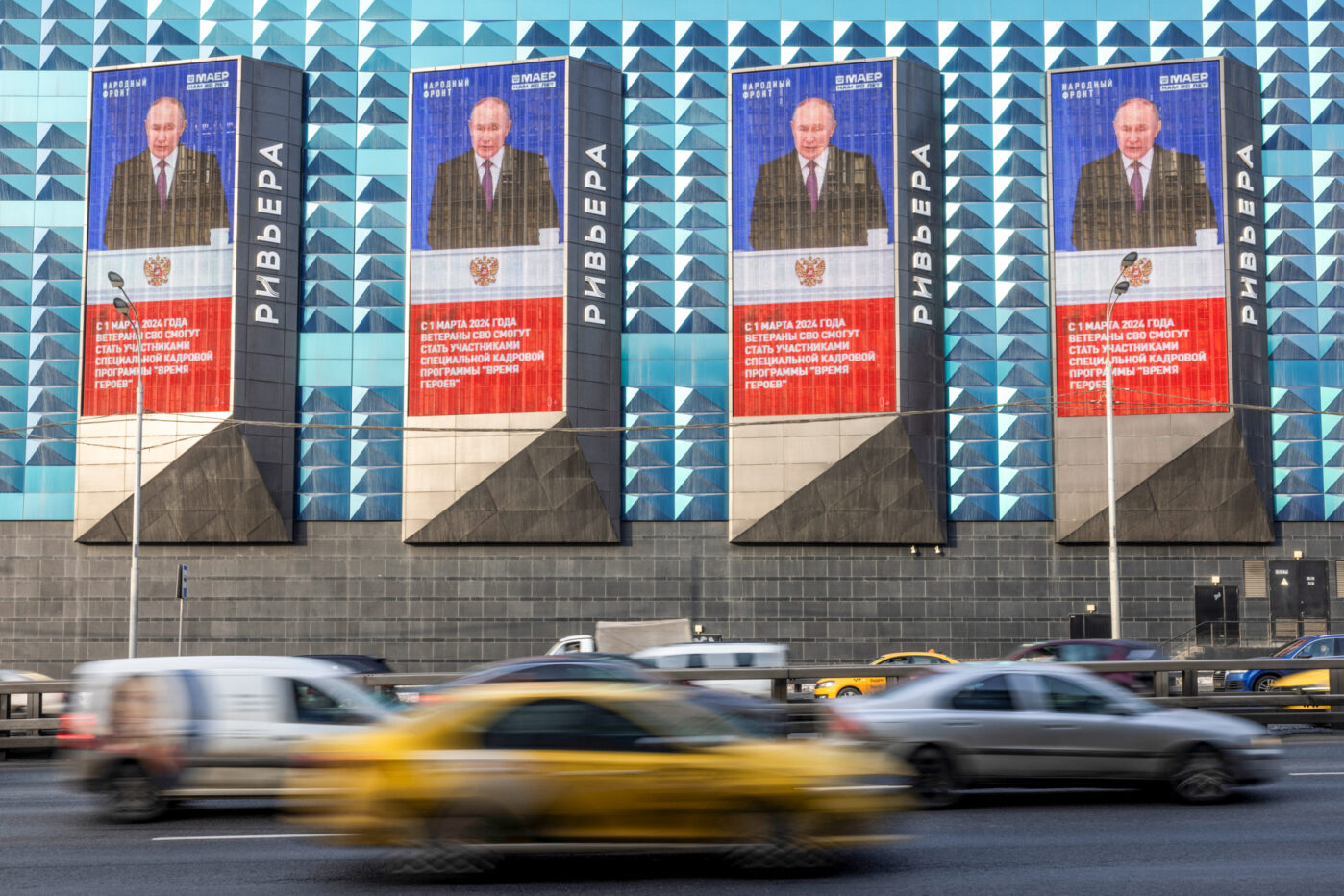 Фото Владимира Путина и цитата из его послания Федеральному Собранию, в Москве
